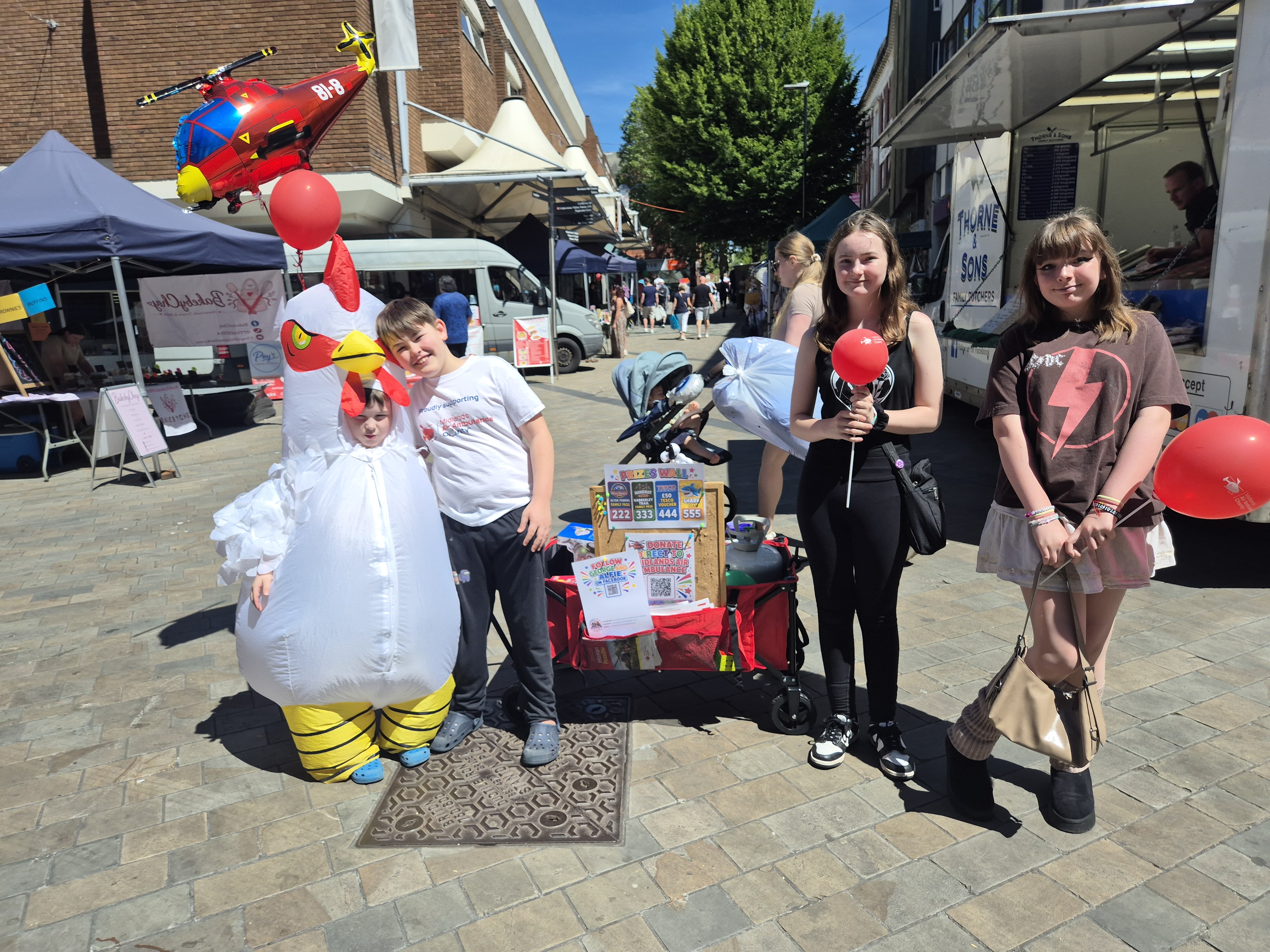 George and Alfie with supporters at an outdoor community fundraising event