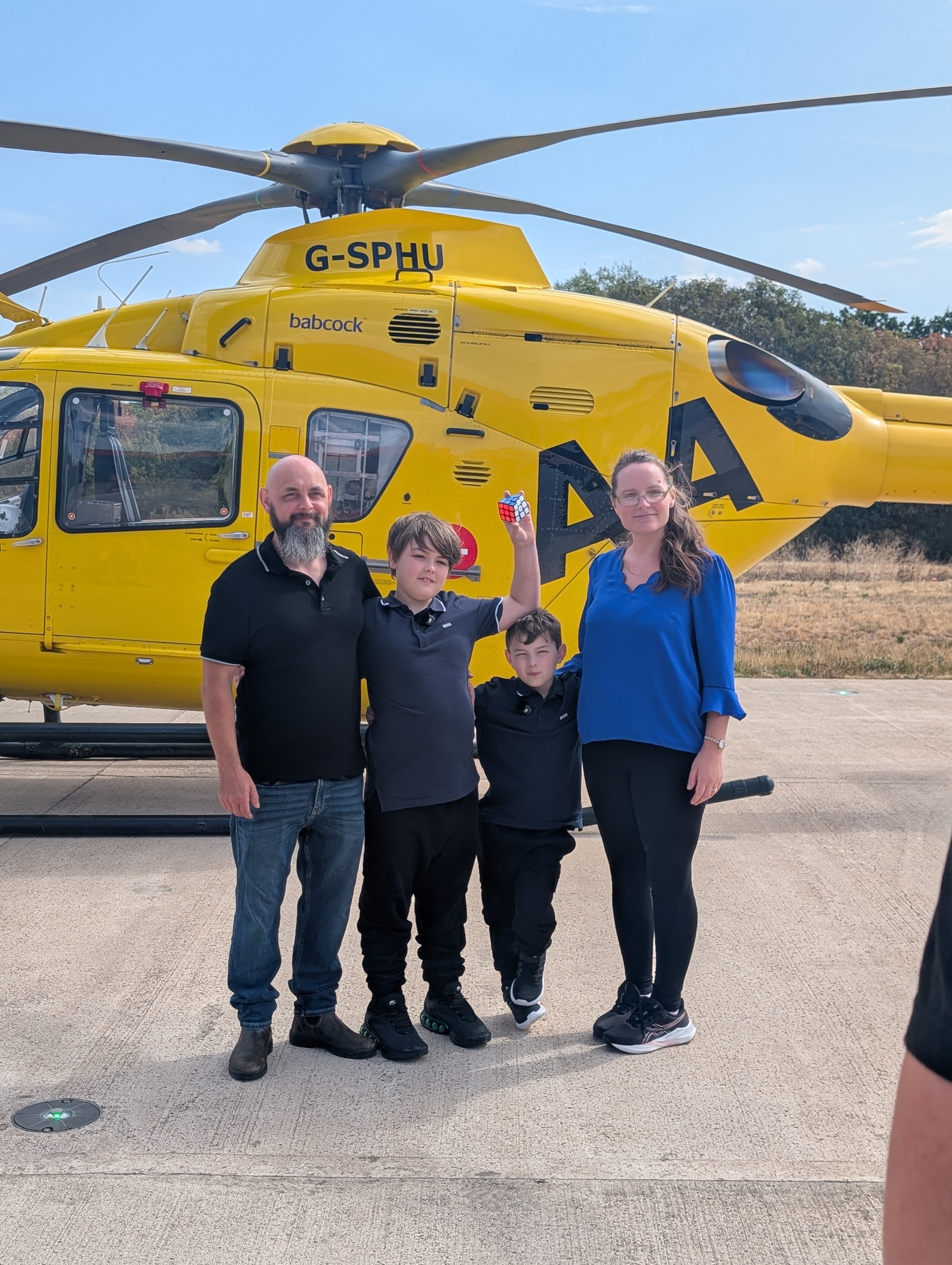 George and Alfie with family members in front of an air ambulance helicopter